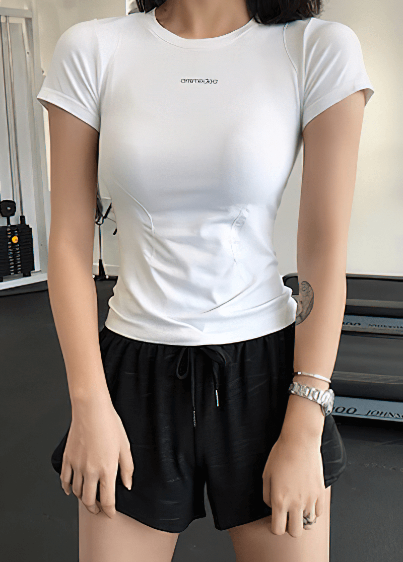 Woman wearing white breathable fitness t-shirt, perfect for running or gym, showing its comfortable and stylish design.